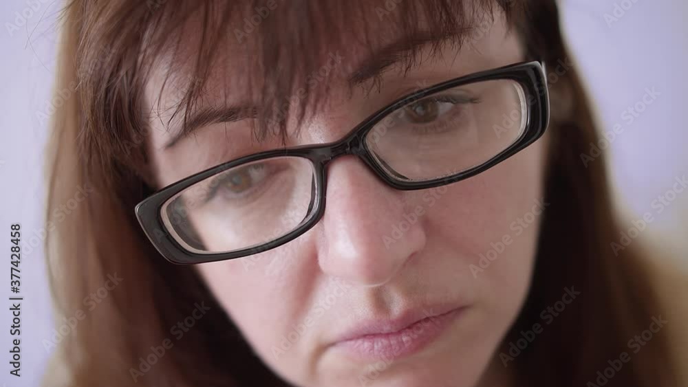 woman with glasses looks with an accusingly scrutinizing look, close up woman with glasses looks with an accusingly scrutinizing look, close up