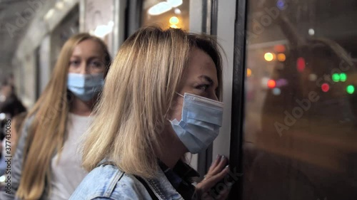 Health-conscious females wearing protective face masks while riding in subway train during epidemic of 2019-ncov. Sane women in underground metro, lockdown, social distancing in public transport