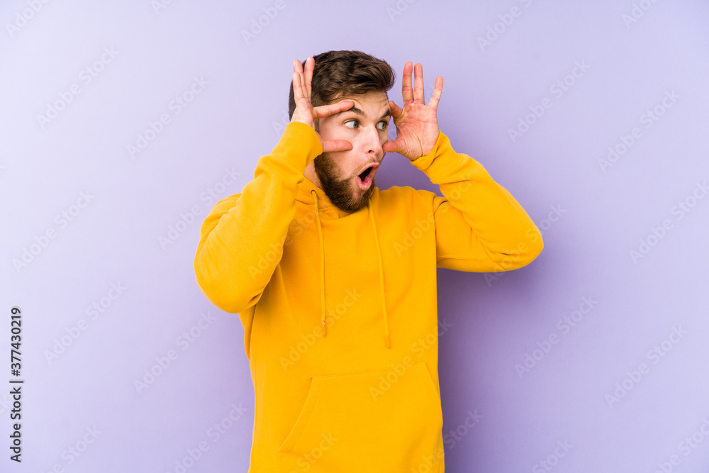 Young caucasian man isolated on purple background keeping eyes opened to find a success opportunity. Young caucasian man isolated on purple background keeping eyes opened to find a success opportunity.