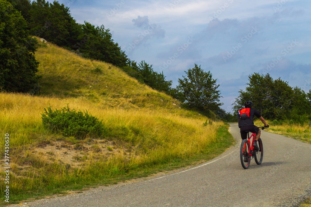 Man mountain biking along a road