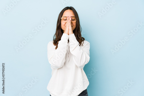 Young mixed race hispanic woman isolated holding hands in pray near mouth, feels confident.