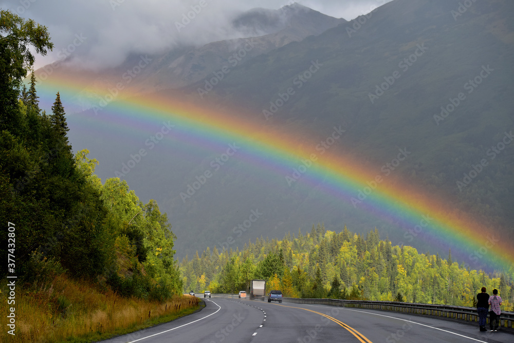 Tourists stop to take pictures of a rainbow over Alaska's Seward Highway.
