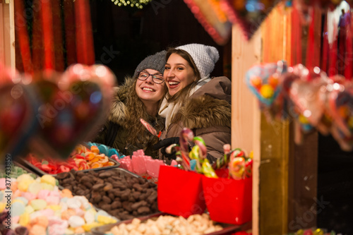 Two beautiful girls choosing candies at an outdoor candy stan