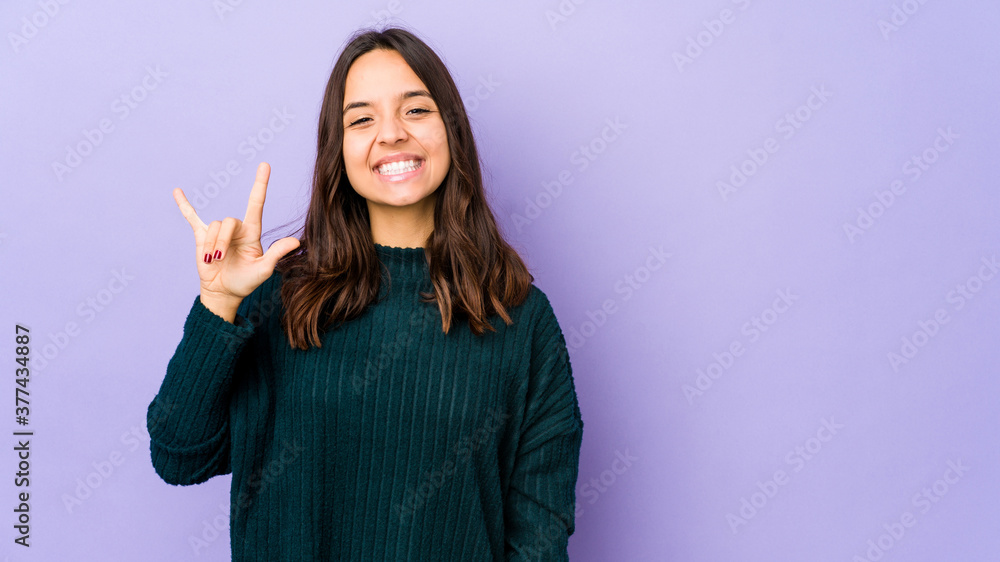 Young mixed race hispanic woman isolated showing a horns gesture as a revolution concept. Young mixed race hispanic woman isolated showing a horns gesture as a revolution concept.