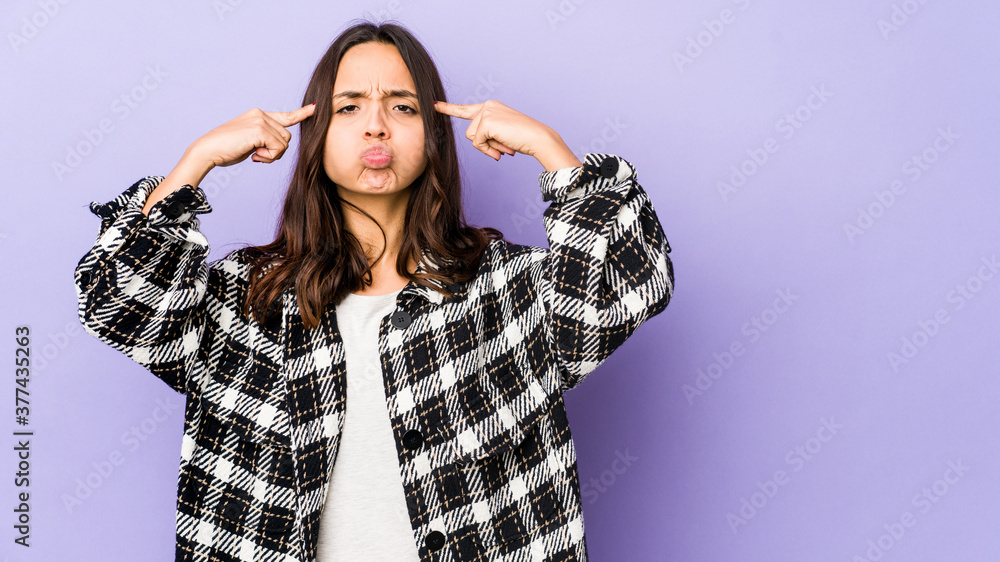 Young mixed race hispanic woman isolated focused on a task, keeping forefingers pointing head. Young mixed race hispanic woman isolated focused on a task, keeping forefingers pointing head.