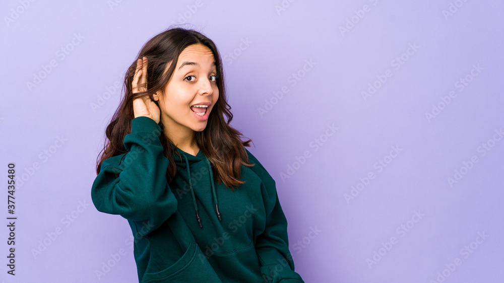 Young mixed race hispanic woman isolated trying to listening a gossip. Young mixed race hispanic woman isolated trying to listening a gossip.