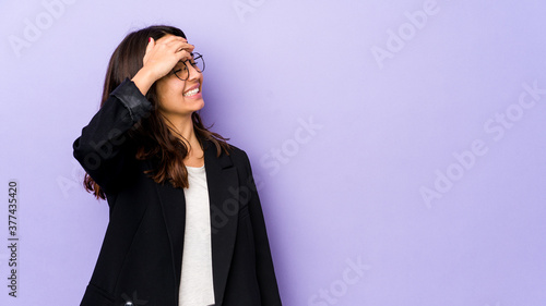 Young mixed race hispanic woman isolated laughs joyfully keeping hands on head. Happiness concept.