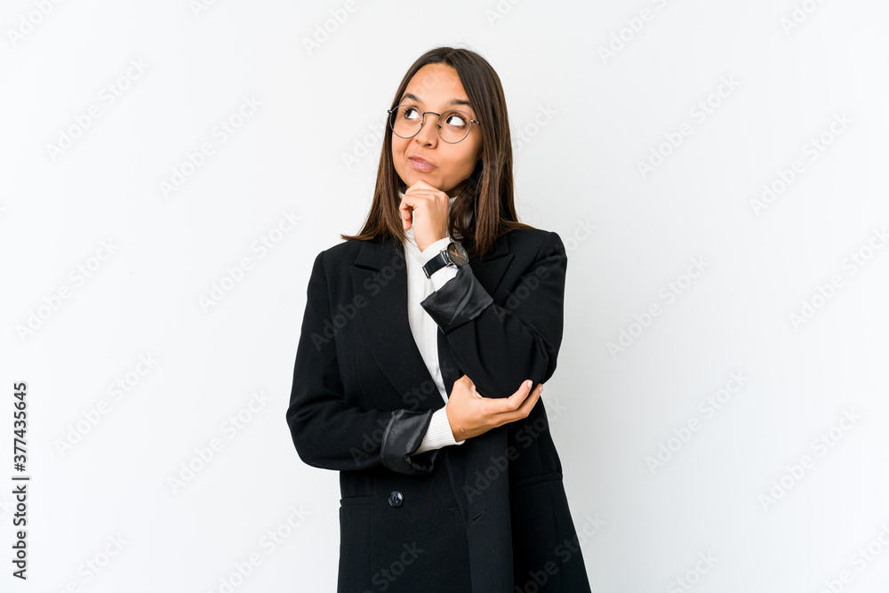 Young mixed race business woman isolated on white background relaxed thinking about something looking at a copy space. Young mixed race business woman isolated on white background relaxed thinking about something looking at a copy space.