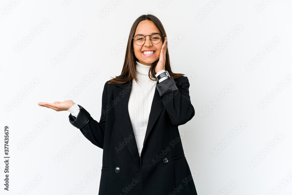 Young mixed race business woman isolated on white background holds copy space on a palm, keep hand over cheek. Amazed and delighted. Young mixed race business woman isolated on white background holds copy space on a palm, keep hand over cheek. Amazed and delighted.