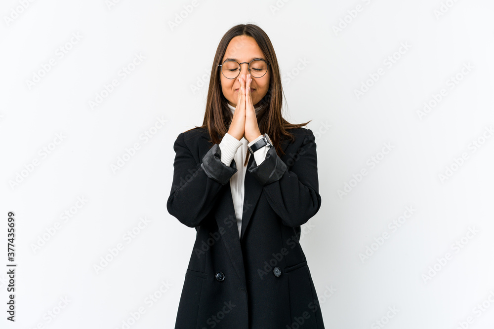 Young mixed race business woman isolated on white background holding hands in pray near mouth, feels confident. Young mixed race business woman isolated on white background holding hands in pray near mouth, feels confident.