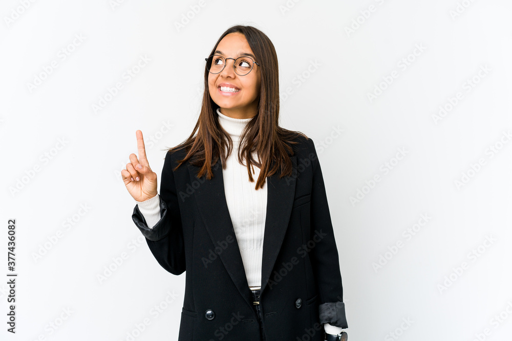 Young mixed race business woman isolated on white background indicates with both fore fingers up showing a blank space. Young mixed race business woman isolated on white background indicates with both fore fingers up showing a blank space.