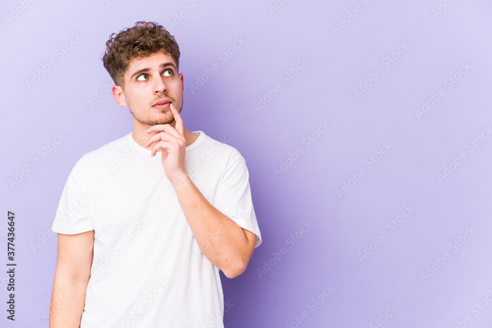 Young blond curly hair caucasian man isolated looking sideways with doubtful and skeptical expression. Young blond curly hair caucasian man isolated looking sideways with doubtful and skeptical expression.
