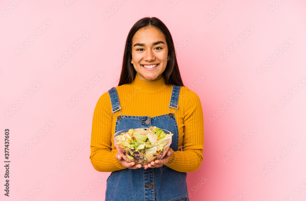 Young asian woman holding a salad isolated happy, smiling and cheerful. Young asian woman holding a salad isolated happy, smiling and cheerful.