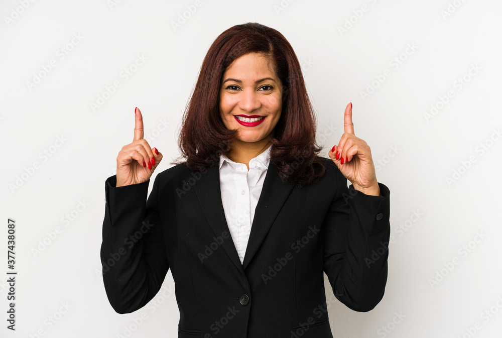 Middle age latin business woman isolated indicates with both fore fingers up showing a blank space. Middle age latin business woman isolated indicates with both fore fingers up showing a blank space.
