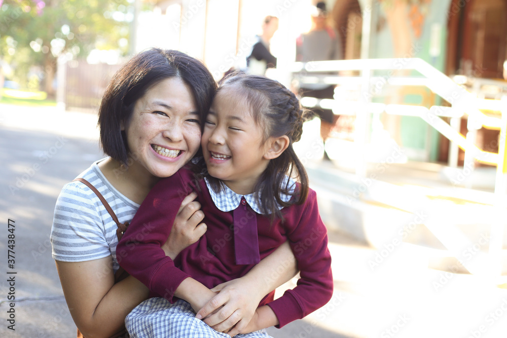 © Claire Bonnor/Austockphoto - School girl sitting on her mother's knee, smiling and laughing © Claire Bonnor/Austockphoto - School girl sitting on her mother's knee, smiling and laughing
