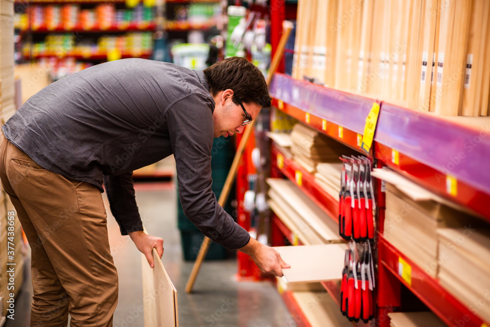 Young man in wood section of hardware store Young man in wood section of hardware store