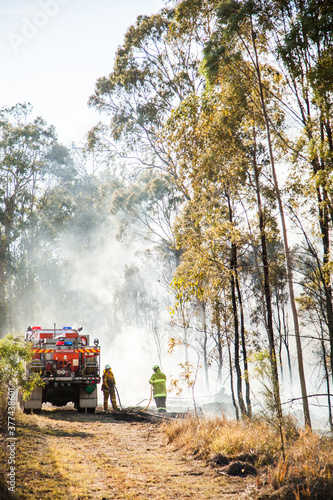NSW rural fire service volunteer firefighter beside truck in fire smoke