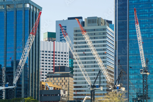Construction cranes working amongst tall city buildings