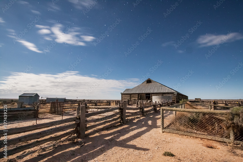 Nighttime photo of a timber shearing shed and cattle yards in the outback Nighttime photo of a timber shearing shed and cattle yards in the outback