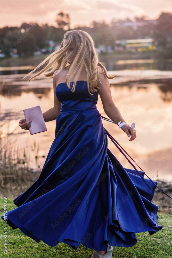 young woman spinning in formal dress in the afternoon light young woman spinning in formal dress in the afternoon light