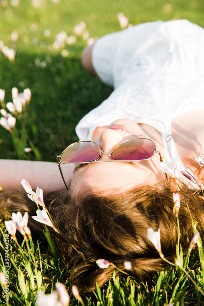 Young girl lying on her back in field of flowers Stock Photo | Adobe Stock