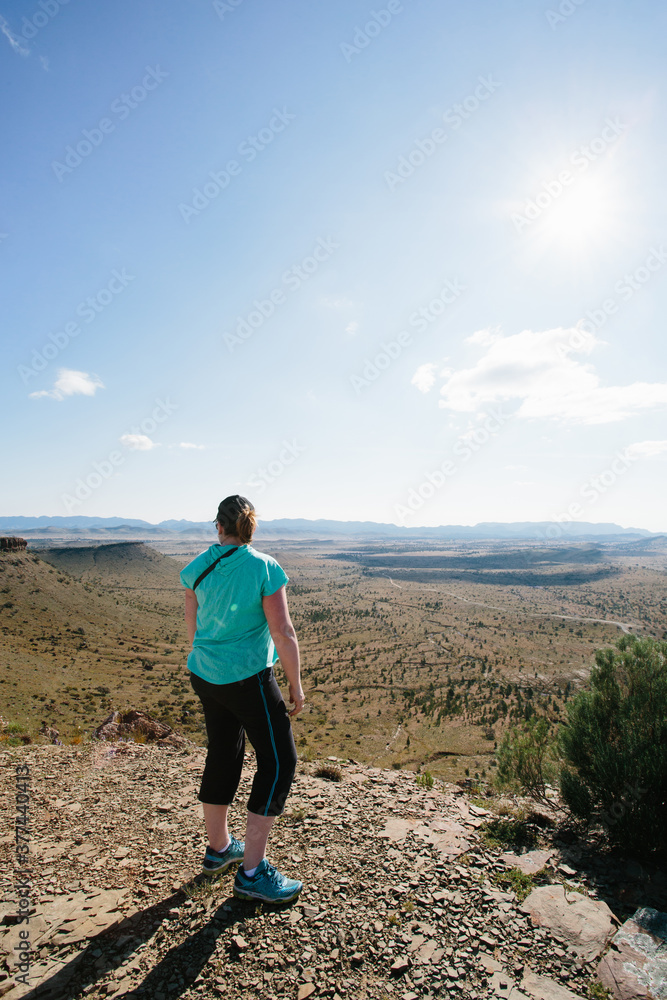 A woman in hiking gear overlooking the rugged landscape of the Flinders Ranges A woman in hiking gear overlooking the rugged landscape of the Flinders Ranges