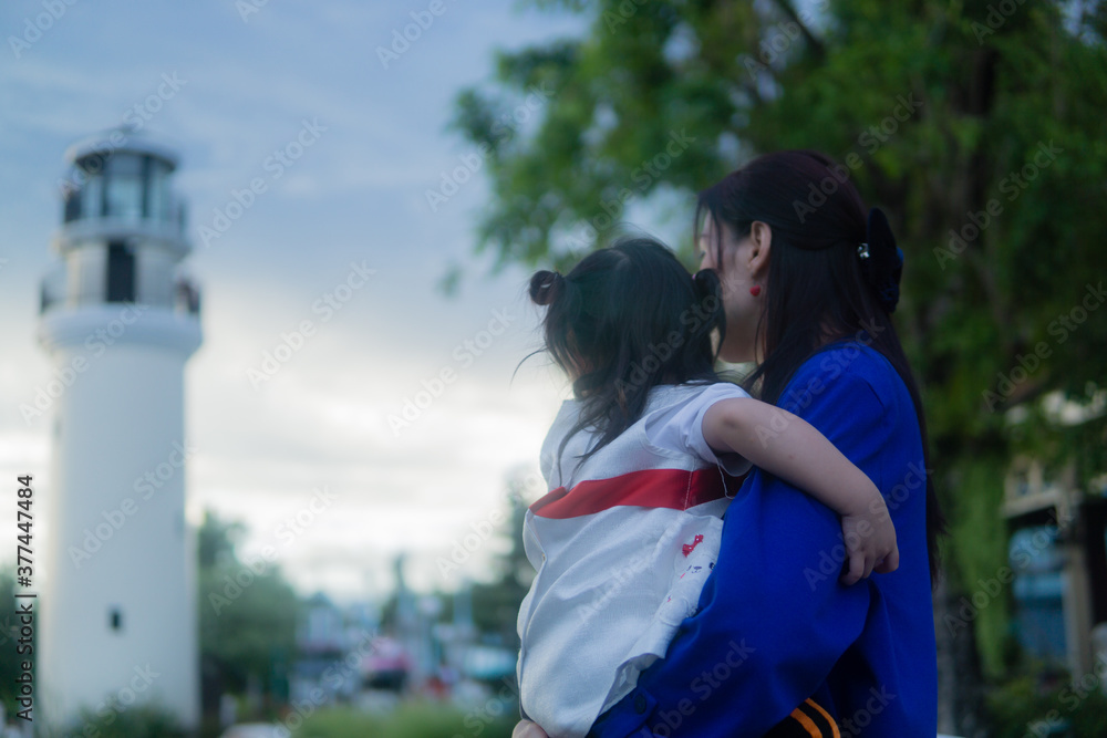 Naklejka premium Happy Asian little girl and mother looking far away.