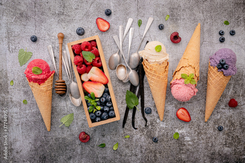 Fototapeta Naklejka Na Ścianę i Meble -  Various of ice cream flavor in cones with berries in wooden box setup on concrete background . Summer and Sweet menu concept.