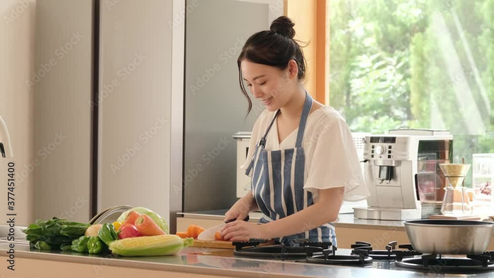 キッチンでにんじんを切る女性 キッチンでにんじんを切る女性