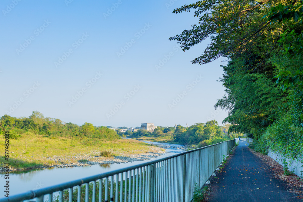 scenery of blue sky and empty cycling road beside the river in early morning in tokyo, japan