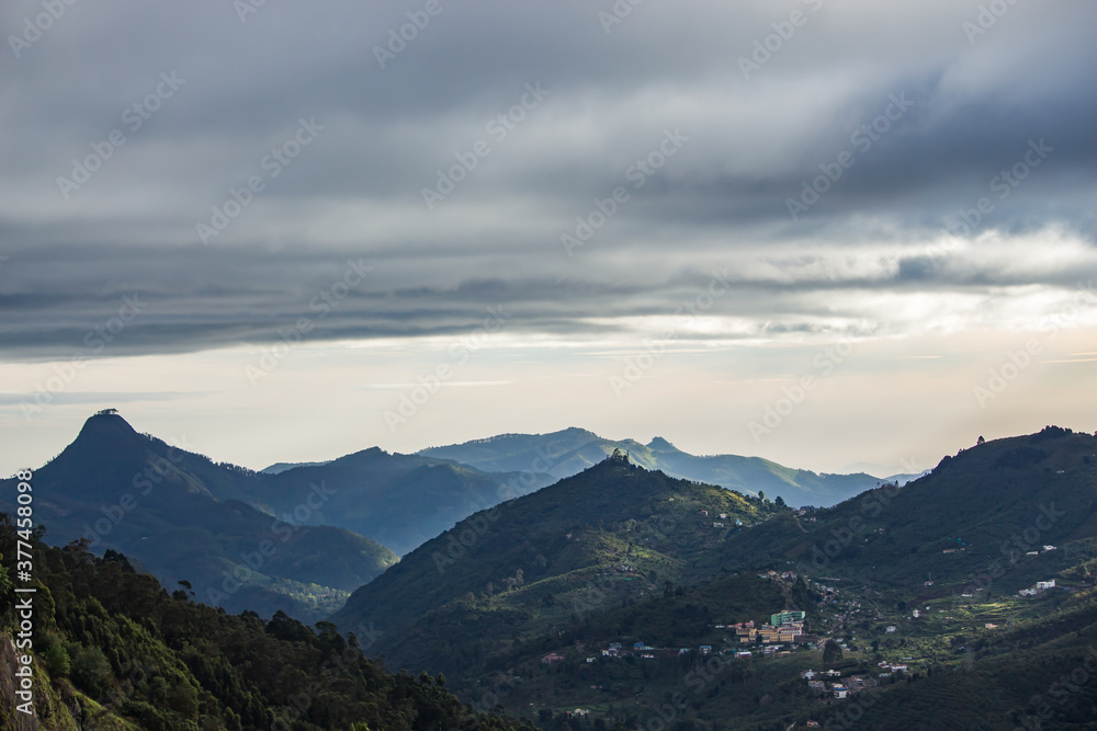 beautiful landscape of hills and mountains silhouette during sunrise. light breaking through cloud cover. mist covered mountains and hills 