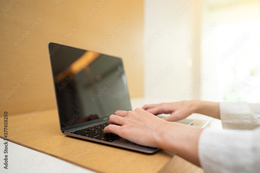 Fototapeta premium Woman working on laptop computer on wooden table. for your advertising text message.
