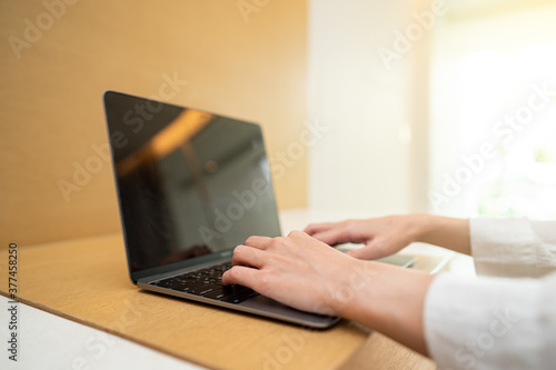 Woman working on laptop computer on wooden table. for your advertising text message.