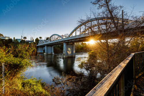 The sun setting under the Fairfield Bridge over the Waikato River in Hamilton, New Zealand