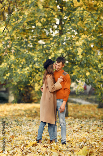 Cute couple in a park. Family in autumn clothes. Man in a brown sweater.