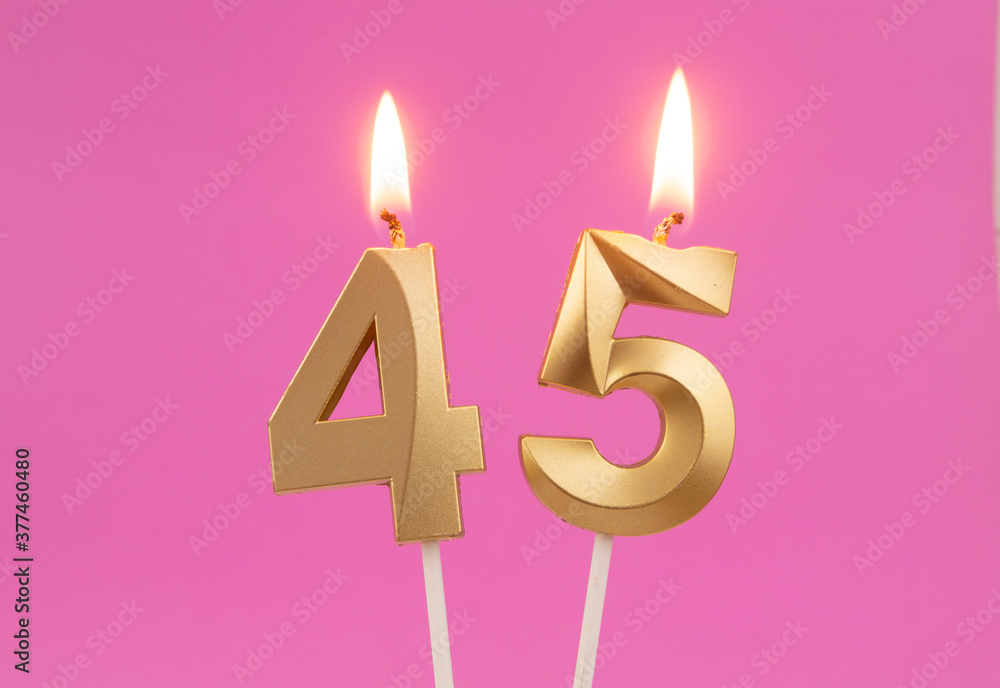 Burning golden birthday candles on pink background, number 45 Burning golden birthday candles on pink background, number 45