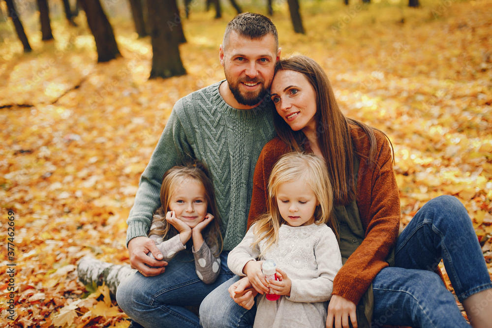 Family in a autumn park. Woman in a red sweater. Cute childrens with parents Family in a autumn park. Woman in a red sweater. Cute childrens with parents