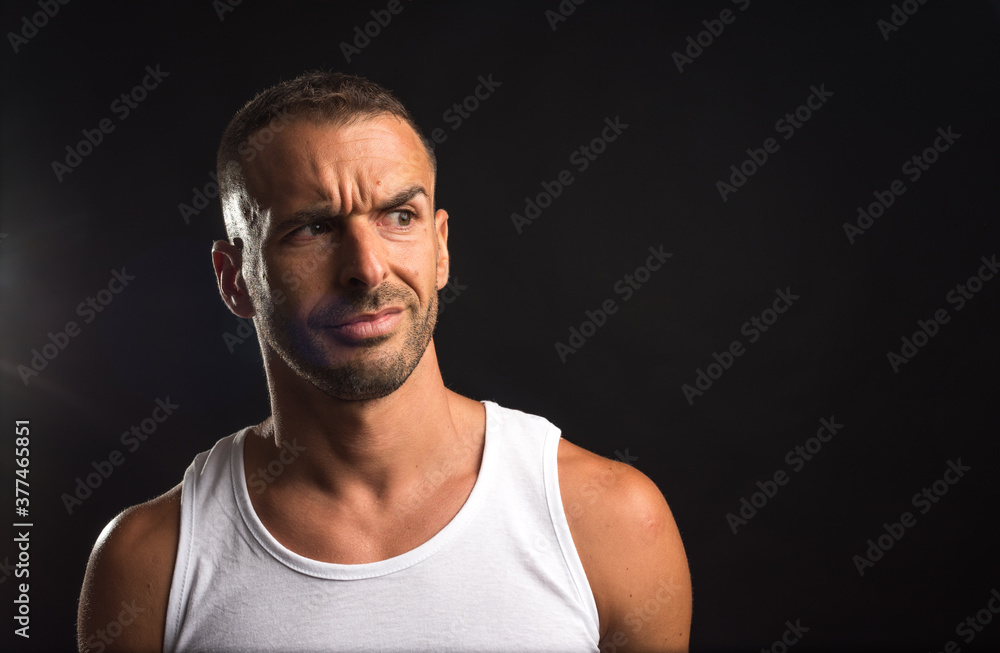 Distrustful athlete man in tank top.