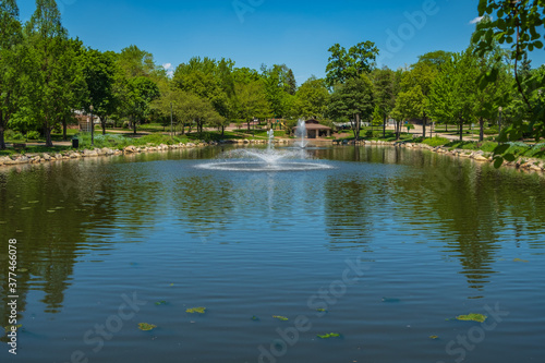 View of park pond with aeration fountains on a summer day.