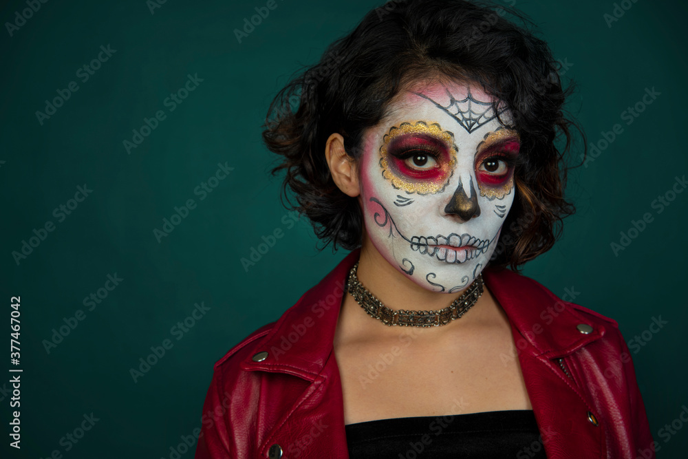 mujer joven latina mexicana maquillaje catrina calavera día de muertos chaqueta roja cabello corto aislada close up fondo verdoso azulado mujer joven latina mexicana maquillaje catrina calavera día de muertos chaqueta roja cabello corto aislada close up fondo verdoso azulado