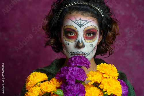Mujer joven millennial bonita maquillaje catrina mexicana latina día de los muertos halloween cara pintada festividad disfraces punk moderna urbana modelo expresión flores colores cempasúchil misterio