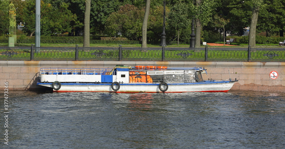 Obraz premium White tourist ship moored to the wall of the city embankment, Kronvergsky Strait embankment, Saint Petersburg, Russia, September 2020