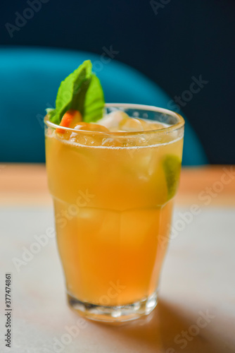 Iced lemon drink with mint on wooden table, indoors. Refreshing summer beverage on a table, alcohol cocktail