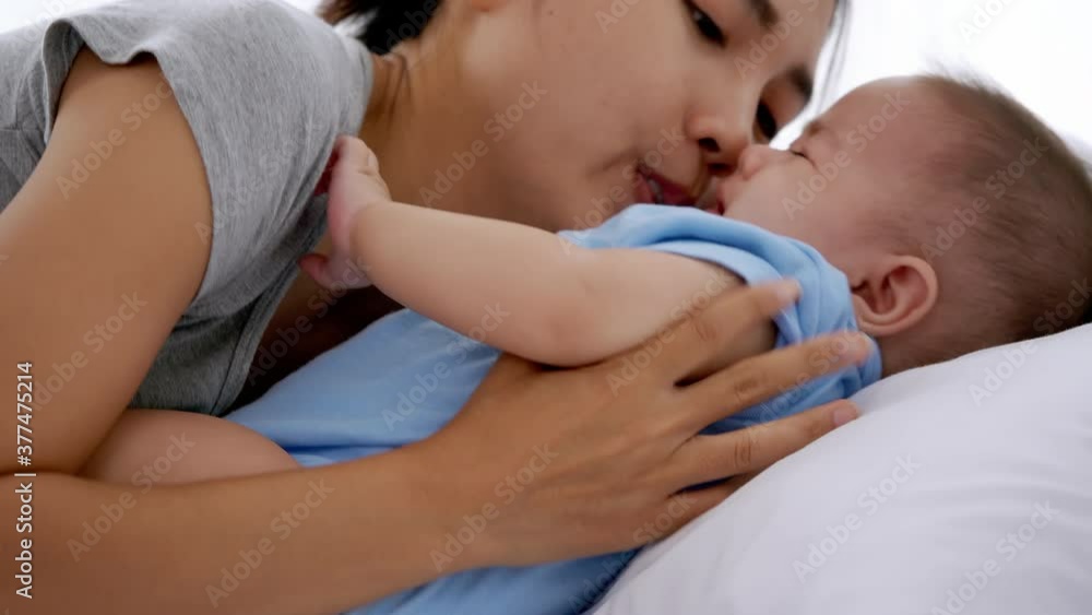 Young mother embracing her little baby on bed. Young mother embracing her little baby on bed.