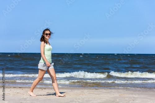 Teenage girl walking on beach 