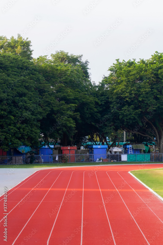 Obraz premium Red running track in sports fields and green grass