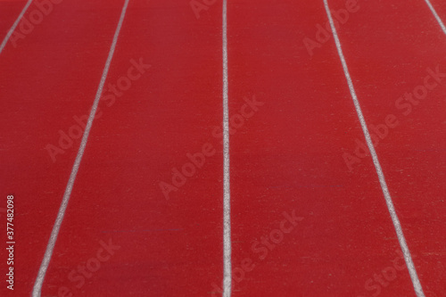 Red running track in sports fields and green grass