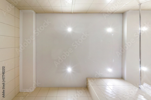 Stretch ceiling white and complex shape with halogen spots lamps and drywall construction in empty room in apartment or house. Suspended ceiling .