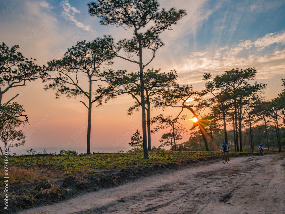 Obraz premium Loei/Thailand-17 Feb 2019:Unacquainted People cycling with Beautiful sunset on Phu Kradueng mountain in Loei City Thailand.Phu Kradueng national park the famous Travel destination