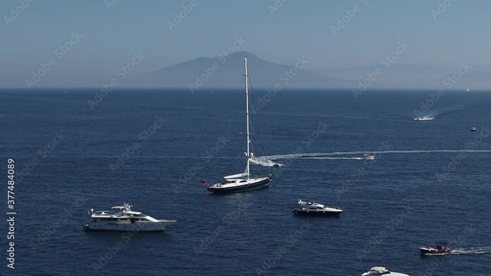 Aerial shot of luxury boats in sea near coastal city on sunny day on the Capri Island Italy Aerial shot of luxury boats in sea near coastal city on sunny day on the Capri Island Italy
